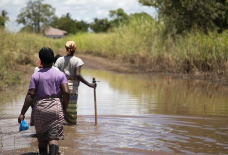 Women walking along a flooded path in Buzi, Mozambique