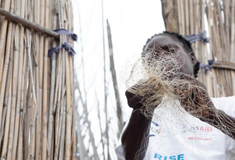 An anonymous woman holds a fishing net in one of Zambia's remote fishing camps.